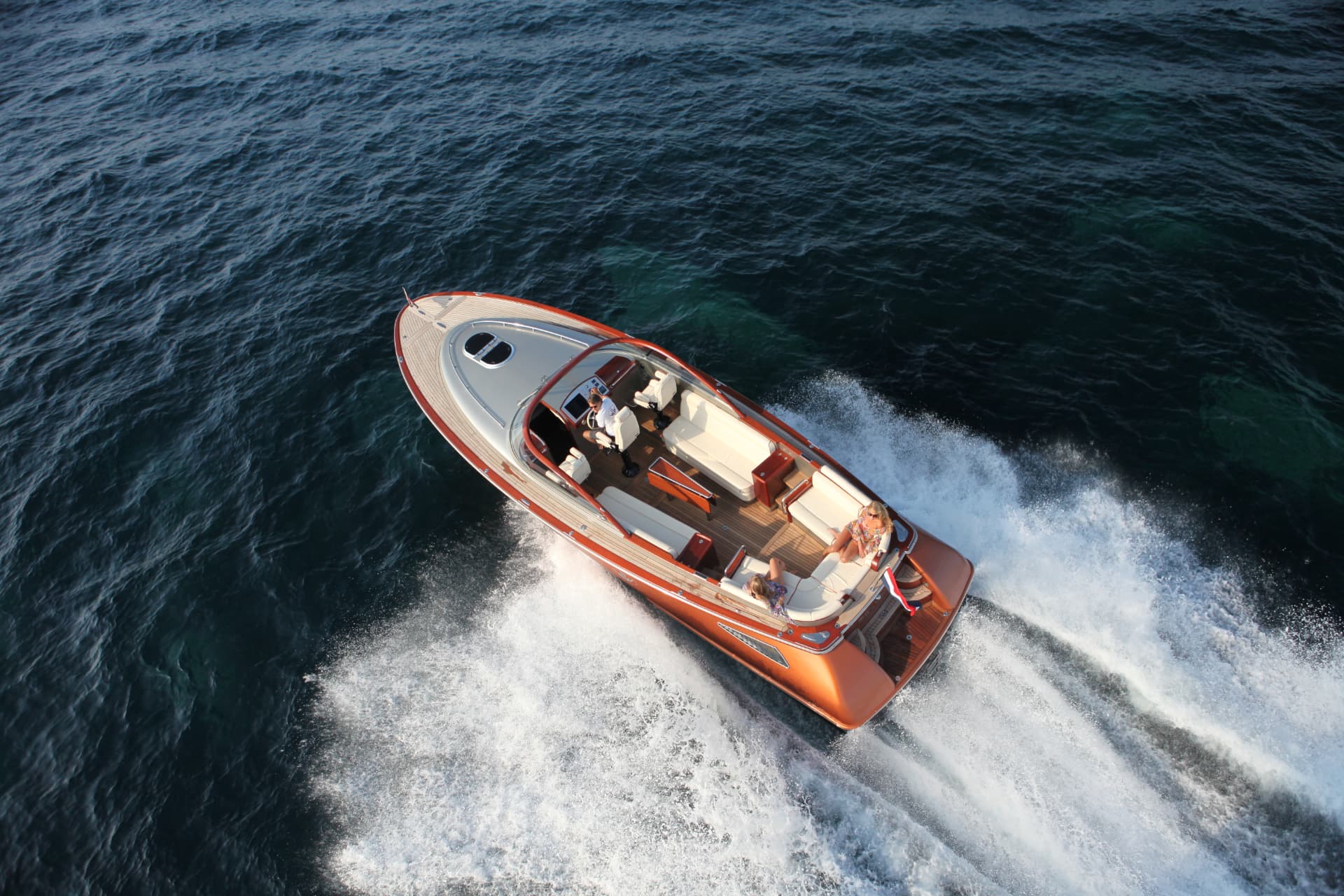 Luchtfoto van een Wajer 37 op snelheid met schipper en gasten aan boord