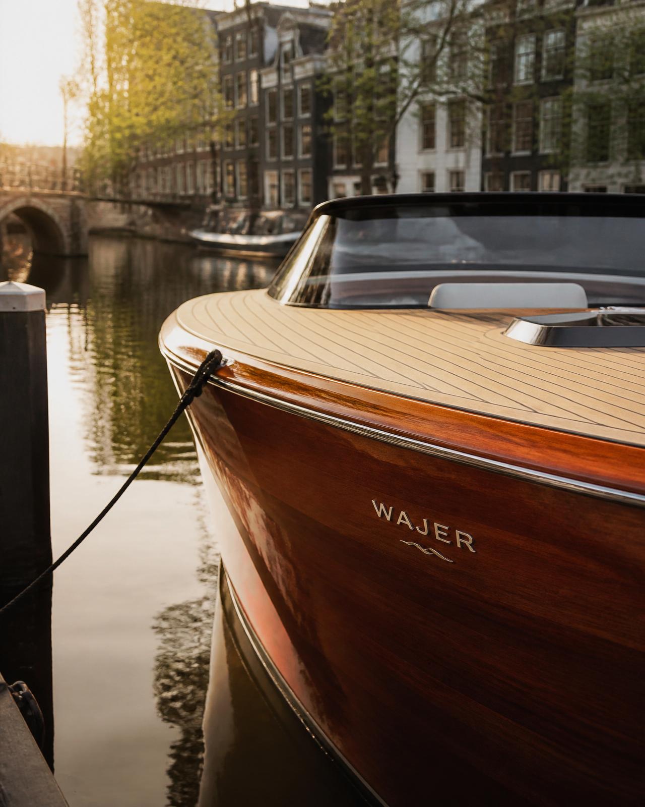 Detail van de gelakte houten romp en het teakdek van een Wajer in een Amsterdamse gracht